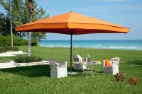 Sonnenschirm-Supremo-von-Caravita-orange-im-Garten-am-Meer-00